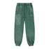 Green sweatpants with geometric design and small logo on a white background